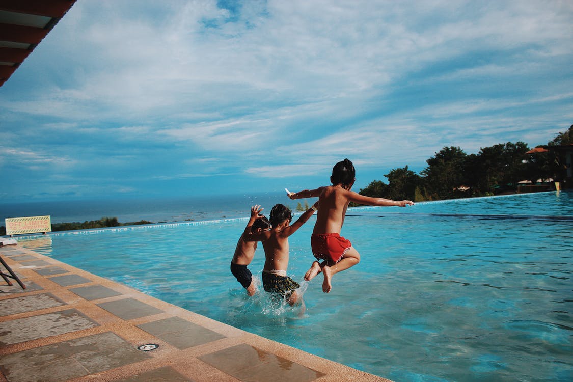 children jumping into pool