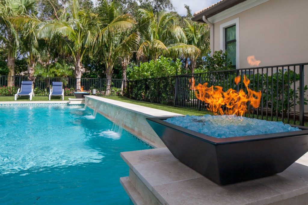 Gas fire pit next to a pool