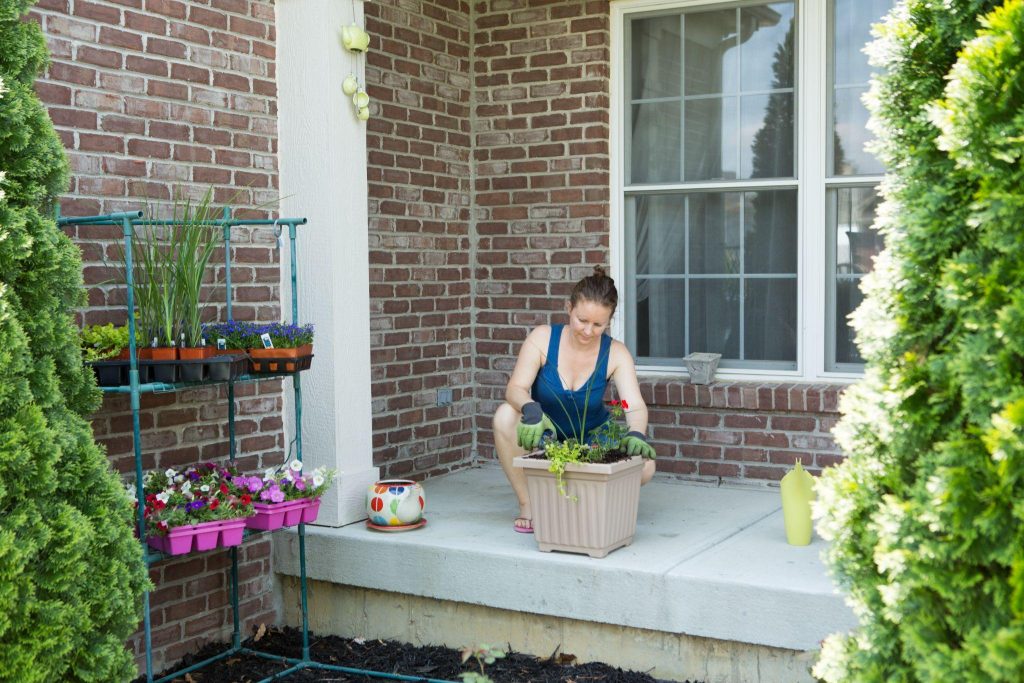 Woman tending to newly potted plants on her patio